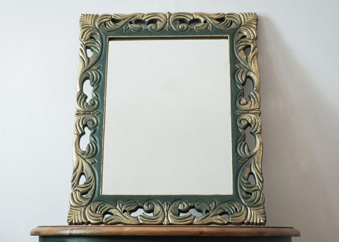 A dark green gothic Art Nouveau style small mirror with gold edges.