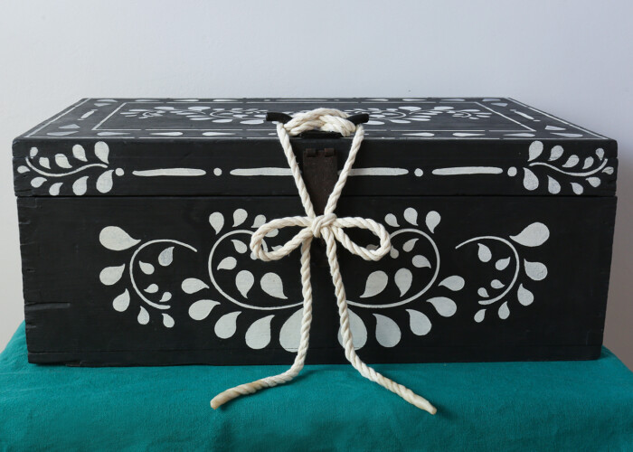 Front of a hand painted storage wooden box in black and white with rope fastening. Painted using Annie Sloan paint. Upcycled using stencils.