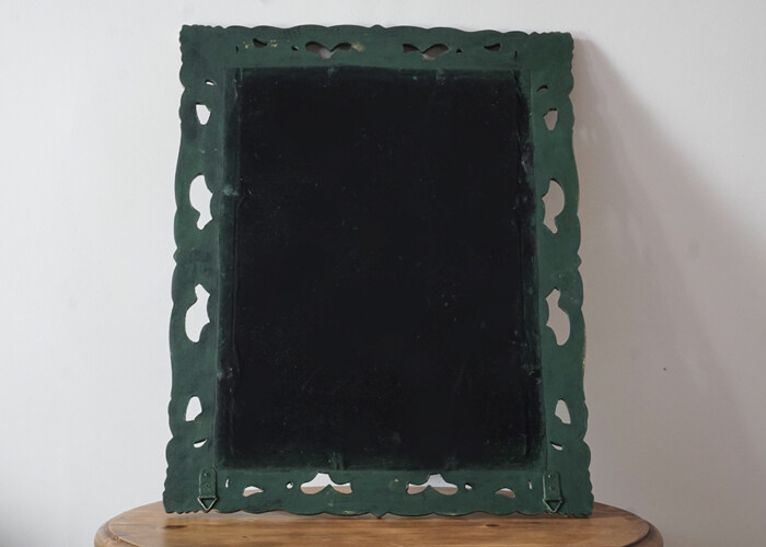 The back of the small Gothic-style dark green mirror with gold floral edges