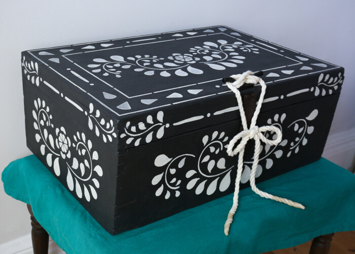 Wooden box originally a fisherman's box, hand painted in black, with white pattern and with a rope fastening. Painted using Annie Sloan paint. Upcycled using stencils.