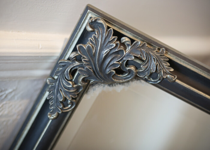 Close up of a renaissance style large black and gold mirror with gold edges for wall or stand alone