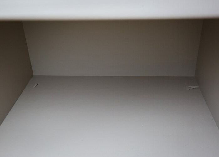 Close up of the botton of a taupe bedside table