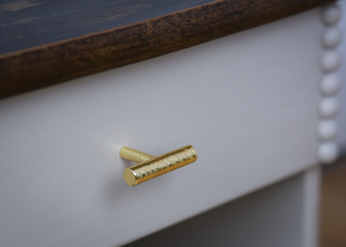 Close up of the gold handle of the bedside table